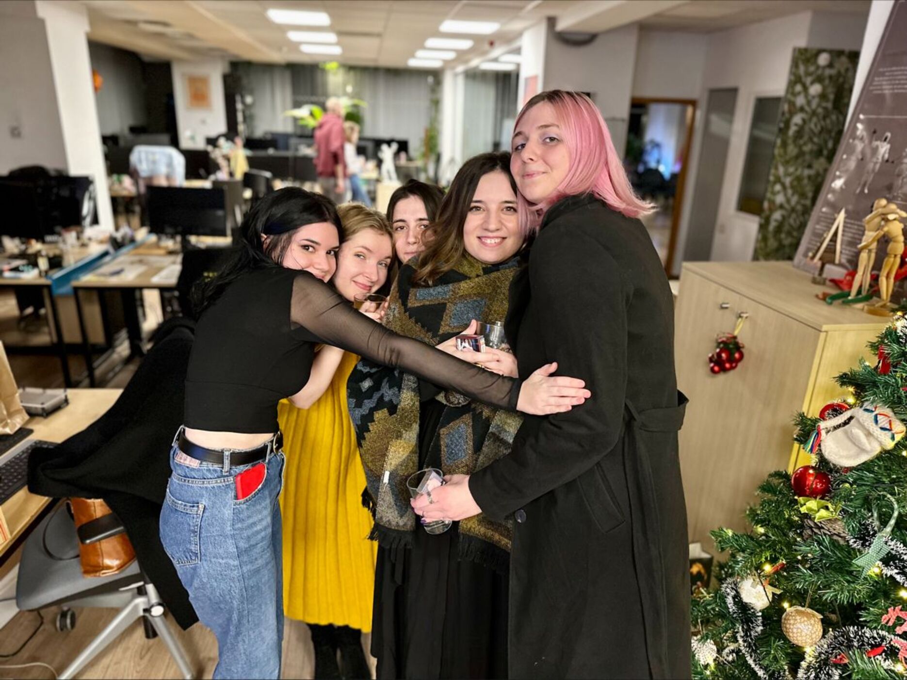 A group of women hugging in a studio