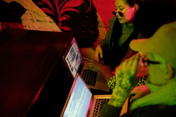 People crowding around a computer screen looking at editing software