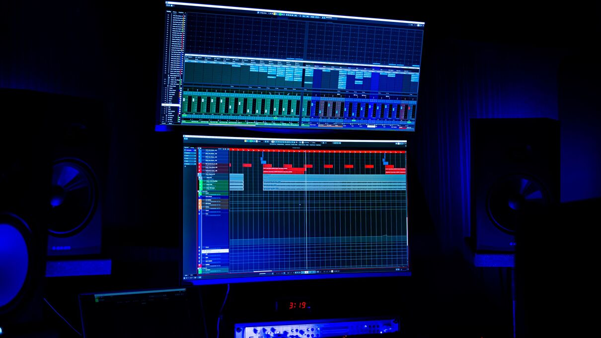 Audio mixing software on a computer screen in a dimly lit room