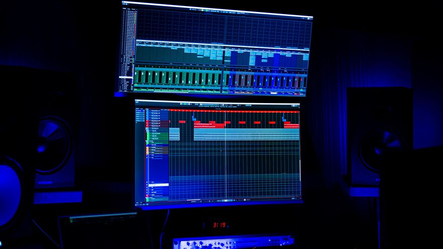 Audio mixing software on a computer screen in a dimly lit room