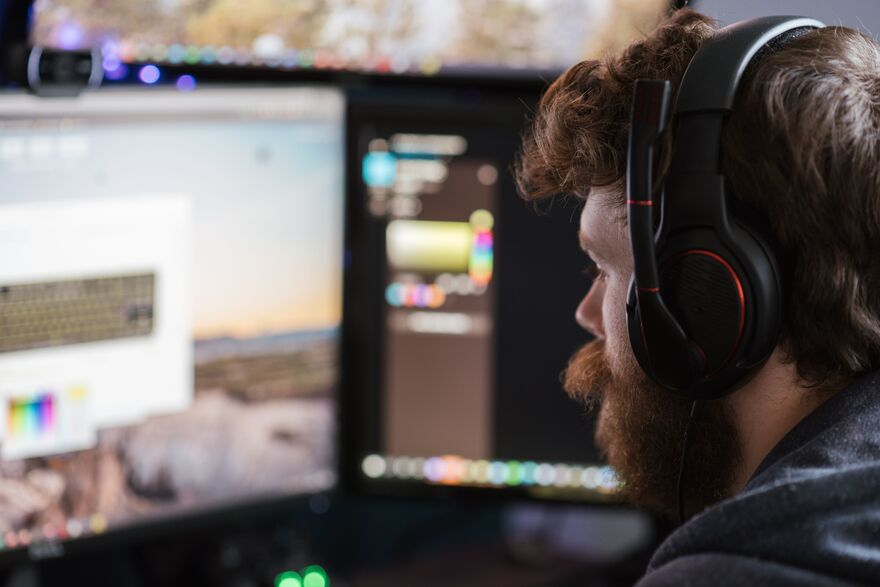 Man with headphones looking at computer screen