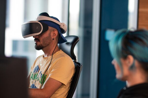 Man with VR headset sitting down while testing a game,