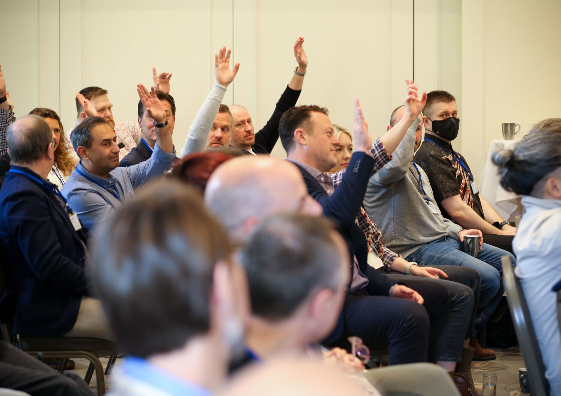 Group of people watching presentation hands raised