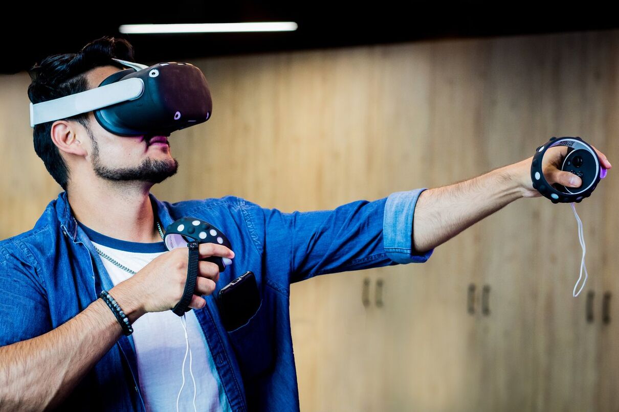 Person using a virtual reality headset and motion controllers during an immersive gaming experience.