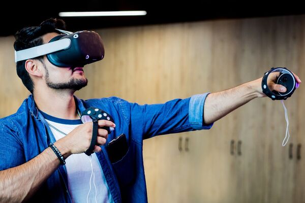 Person using a virtual reality headset and motion controllers during an immersive gaming experience.