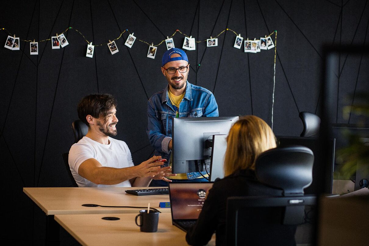 people at work desks laughing and chatting