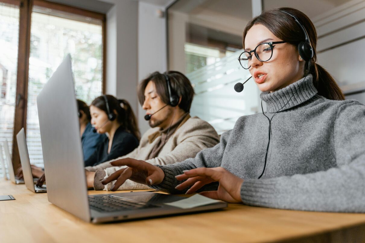Online moderation team working at laptops in a modern office environment